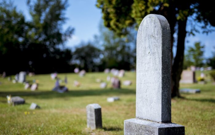 Closeup Shot Of A Gravestone With A Blurred Background At Daytime